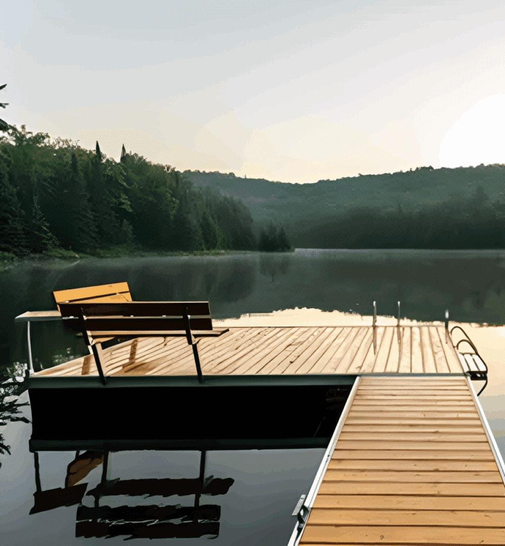 A wooden dock with benches extending over a calm lake surrounded by forest.