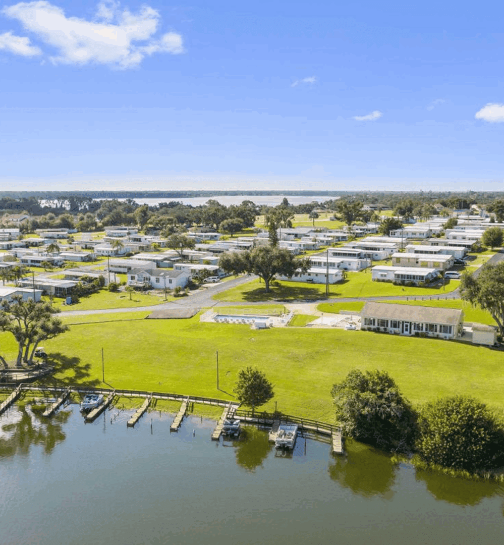 A peaceful waterfront community with docks and green spaces under a clear blue sky.