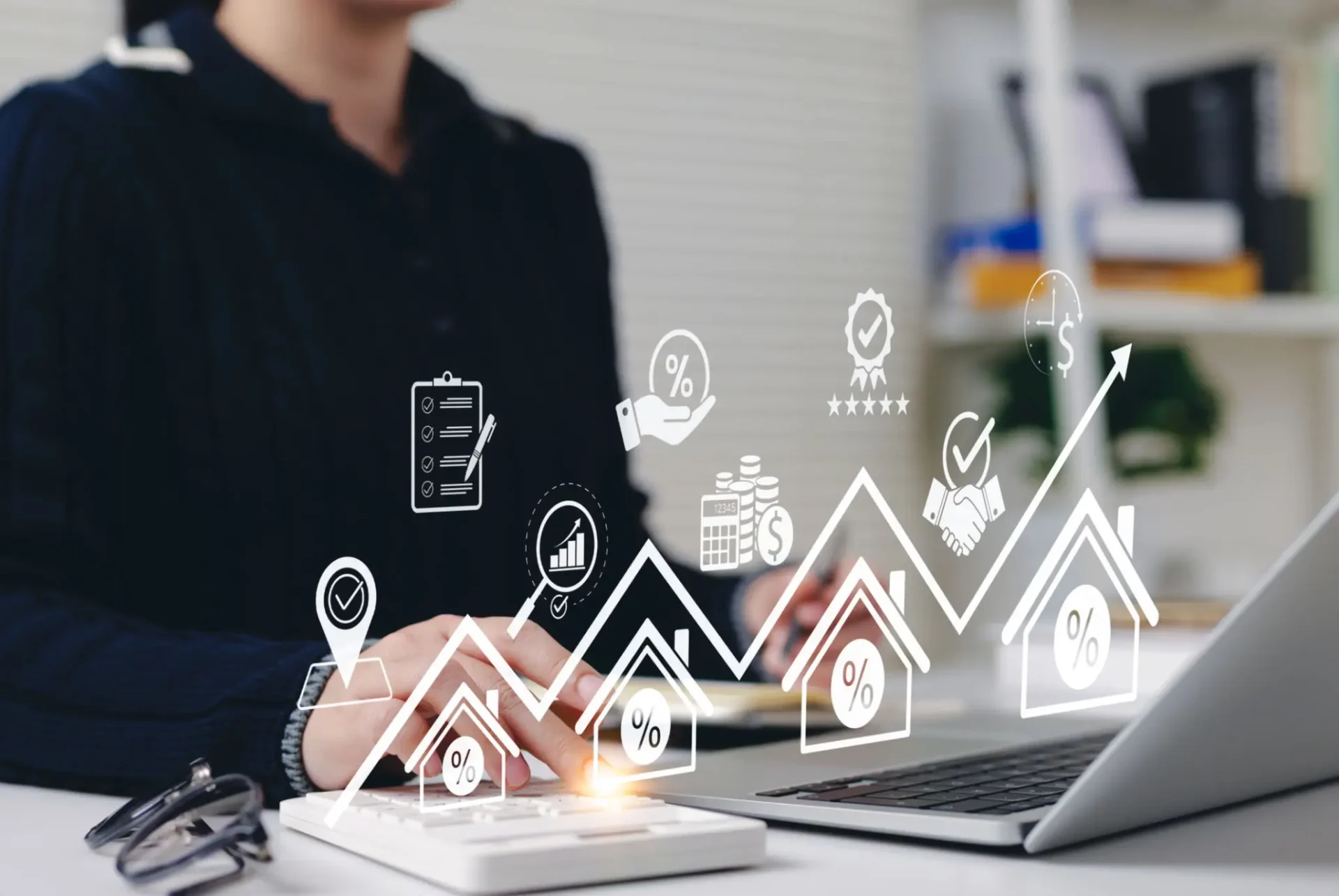 Person working on laptop with digital financial graphs and icons.