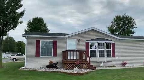 Single-story house with red shutters and a small wooden porch.