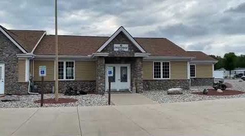 Small community building with stone facade and double doors.
