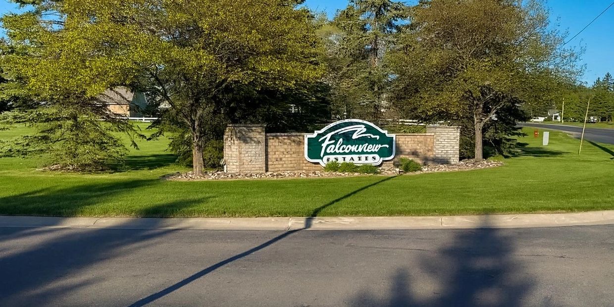 Entrance sign for Falcon Trace residential community under trees.