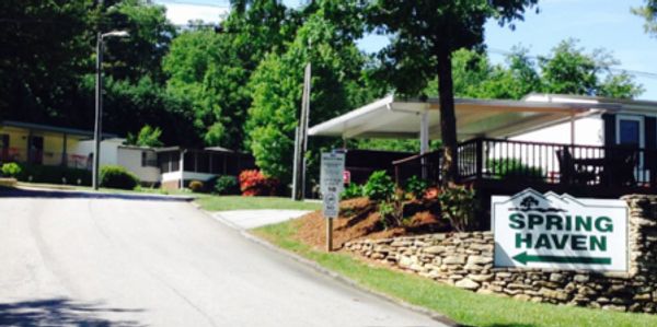 Sign for Country Hill Pines Mobile Home Park on a brick wall.