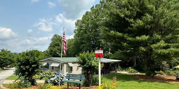 Sign for Country Hill Pines Mobile Home Park on a brick wall.