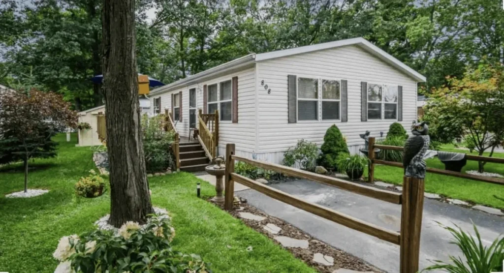 White single-story house with a wooden ramp and green yard.