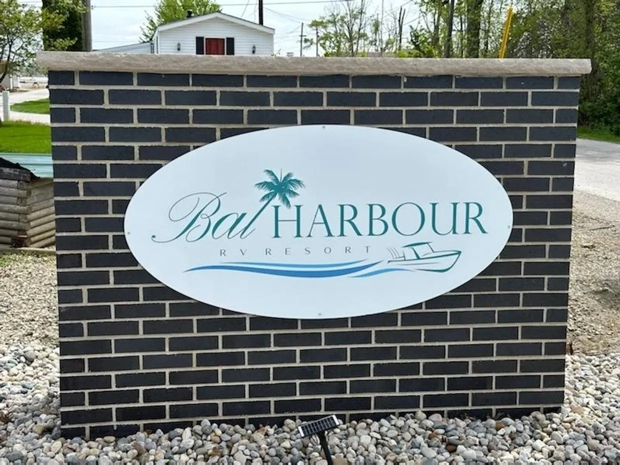 Sign for Bat Harbour with palm tree and boat graphics.