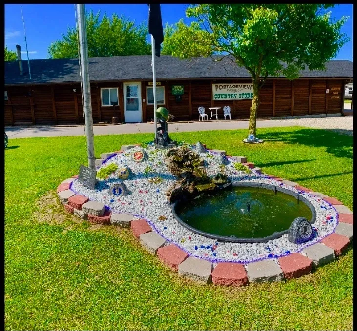 Small garden pond with decorative stones and green lawn.