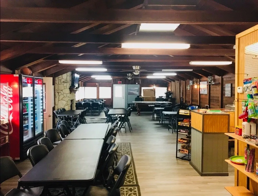 Spacious co-working space with long tables and exposed wooden beams.