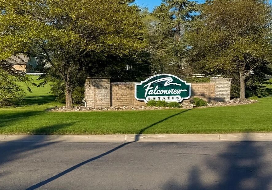 Entrance sign for Falcon Trace residential community under trees.