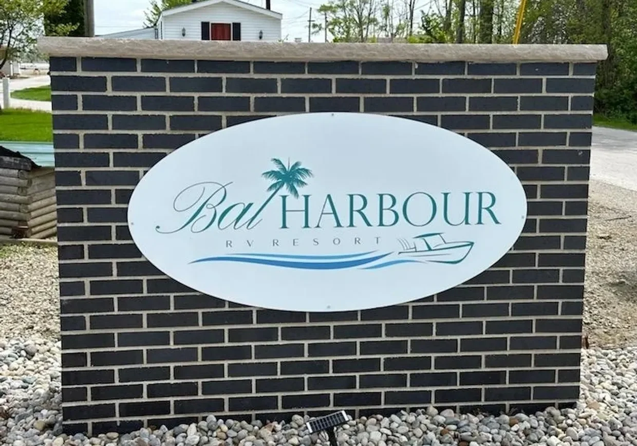 Sign for Bat Harbour with palm tree and boat graphics.